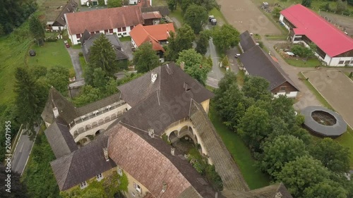 Aerial view of Medieval Castle Halleg in Klagenfurt, Austria, Karyntia. Flight over beautiful castle surrounded by Mountains and forests. Walls covered with ivy. photo