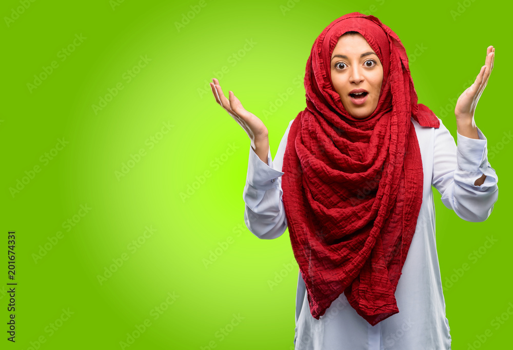 Young arab woman wearing hijab happy and surprised cheering expressing wow gesture Young arab woman wearing hijab happy and surprised cheering expressing wow gesture
