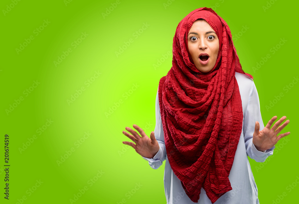 Young arab woman wearing hijab happy and surprised cheering expressing wow gesture Young arab woman wearing hijab happy and surprised cheering expressing wow gesture