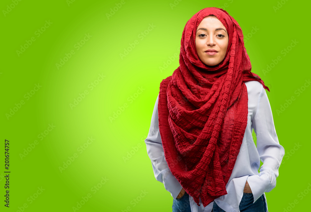 Young arab woman wearing hijab confident and happy with a big natural smile looking at camera Young arab woman wearing hijab confident and happy with a big natural smile looking at camera
