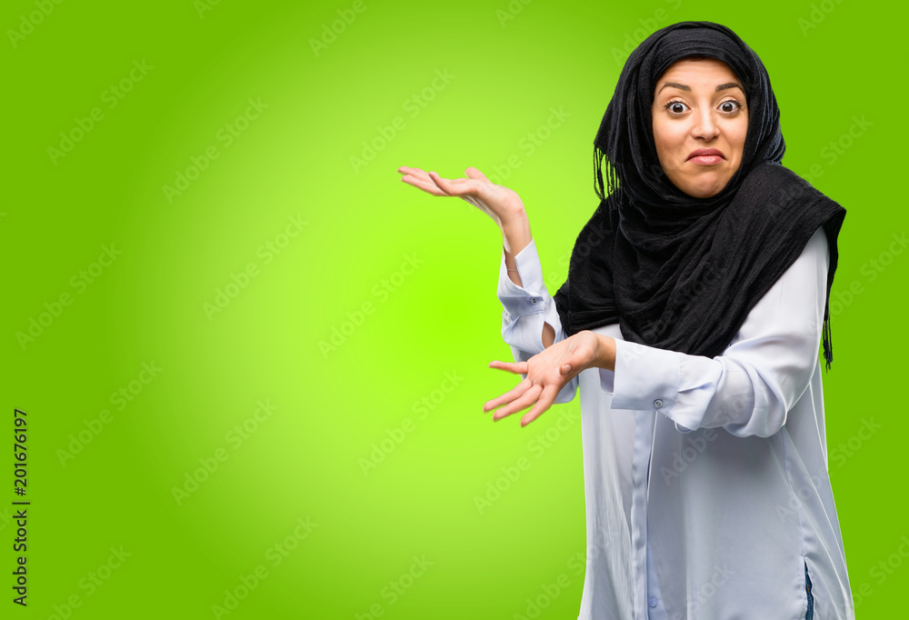 Young arab woman wearing hijab doubt expression, confuse and wonder concept, uncertain future Young arab woman wearing hijab doubt expression, confuse and wonder concept, uncertain future