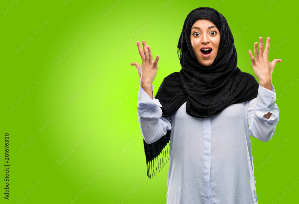 Young arab woman wearing hijab happy and surprised cheering expressing wow gesture Young arab woman wearing hijab happy and surprised cheering expressing wow gesture