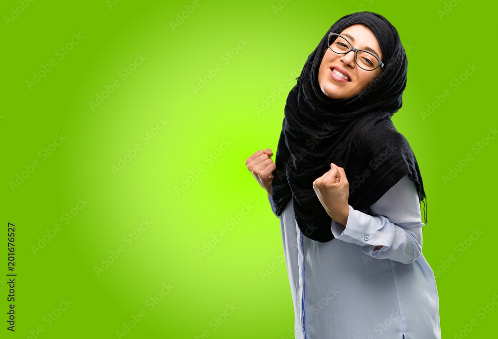 Young arab woman wearing hijab happy and excited celebrating victory expressing big success, power, energy and positive emotions. Celebrates new job joyful Young arab woman wearing hijab happy and excited celebrating victory expressing big success, power, energy and positive emotions. Celebrates new job joyful