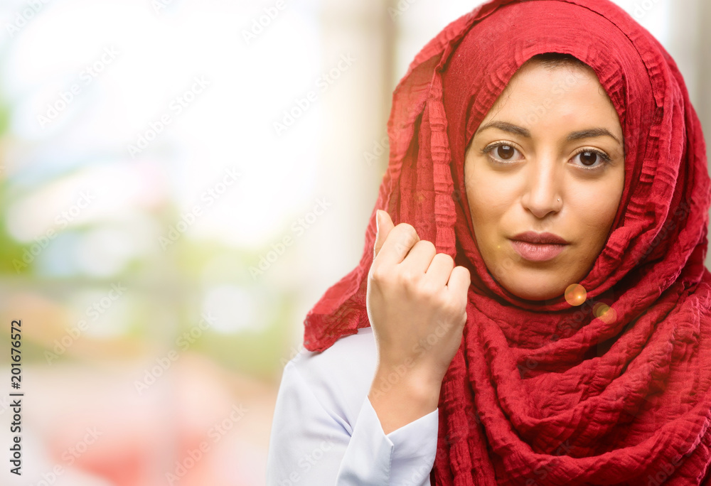 Young arab woman wearing hijab with crossed arms confident and serious
