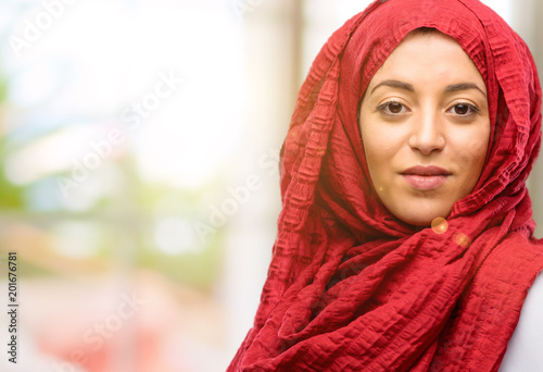 Young arab woman wearing hijab confident and happy with a big natural smile looking at camera