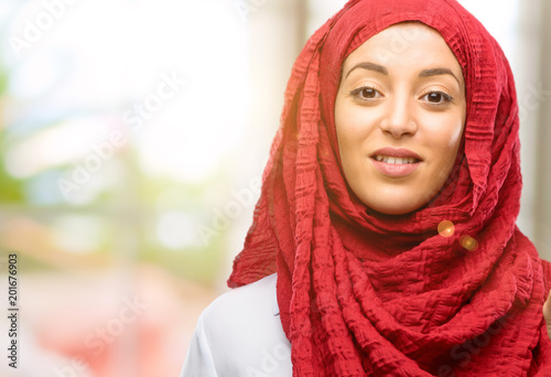 Young arab woman wearing hijab raising his finger, the number one