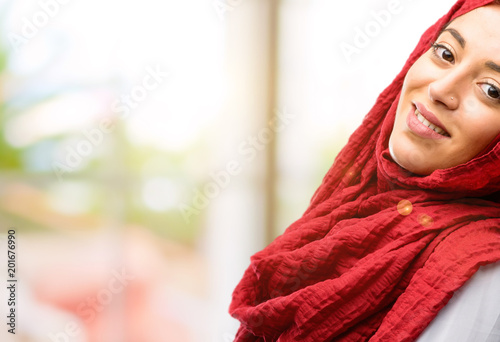 Young arab woman wearing hijab confident and happy with a big natural smile inviting to enter