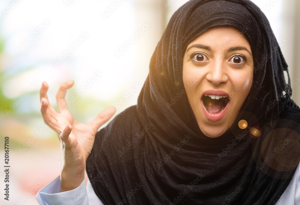 Young arab woman wearing hijab terrified and nervous expressing anxiety and panic gesture, overwhelmed Young arab woman wearing hijab terrified and nervous expressing anxiety and panic gesture, overwhelmed