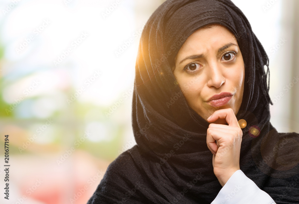 Young arab woman wearing hijab thinking thoughtful with smart face Young arab woman wearing hijab thinking thoughtful with smart face