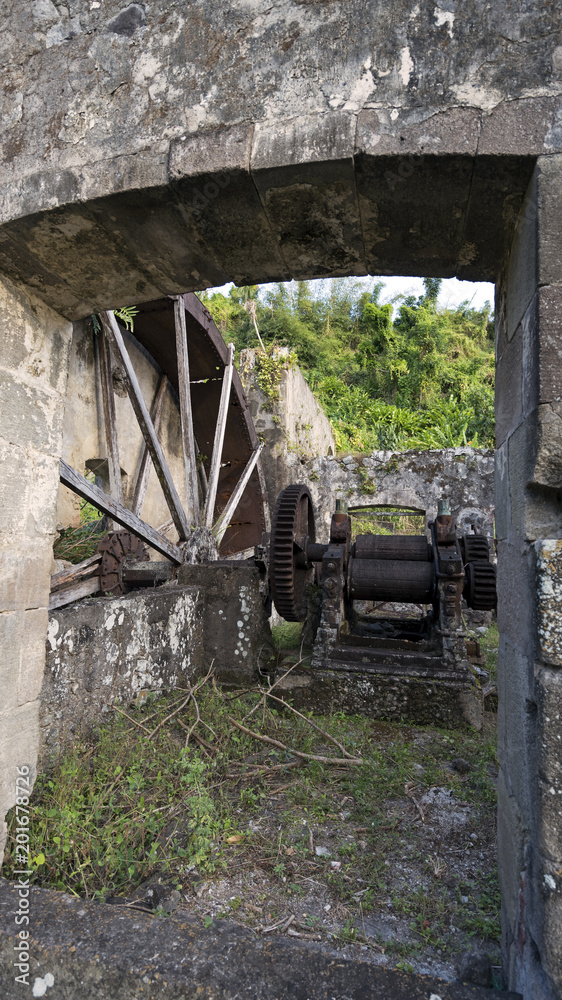 Obraz premium Sugar Mill ruins in Dominica. Sugar was the source of West Indies wealth for centuries. Growing sugar cane and processing was labor intensive and grueling, leading to intensive use of slave labor.