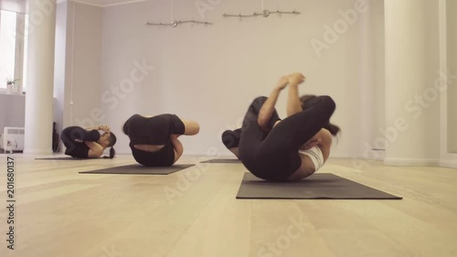 Yoga class. Ashtanga yoga. Garbha pindasana. Funny situation - the man was entangled in a difficult pose, the teacher helps him, class laughing