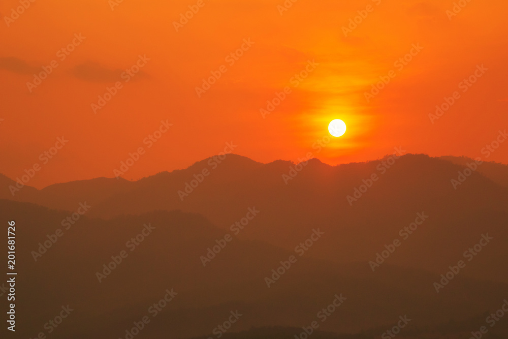 Red and orange warm sunlight in the sky during sunset with mountain range in foreground, shade and shadow, sunset sunrise Red and orange warm sunlight in the sky during sunset with mountain range in foreground, shade and shadow, sunset sunrise