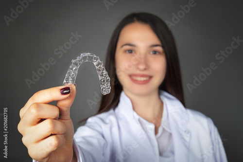 Beautiful smiling Turkish girl keeping invisaligner on her hand photo