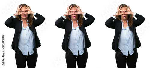 Middle age business woman looking at camera through her fingers in ok gesture. Imitating binoculars over white background