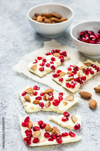 White chocolate bark with dried fruit and nuts on concrete background. Selective focus, space for text. 