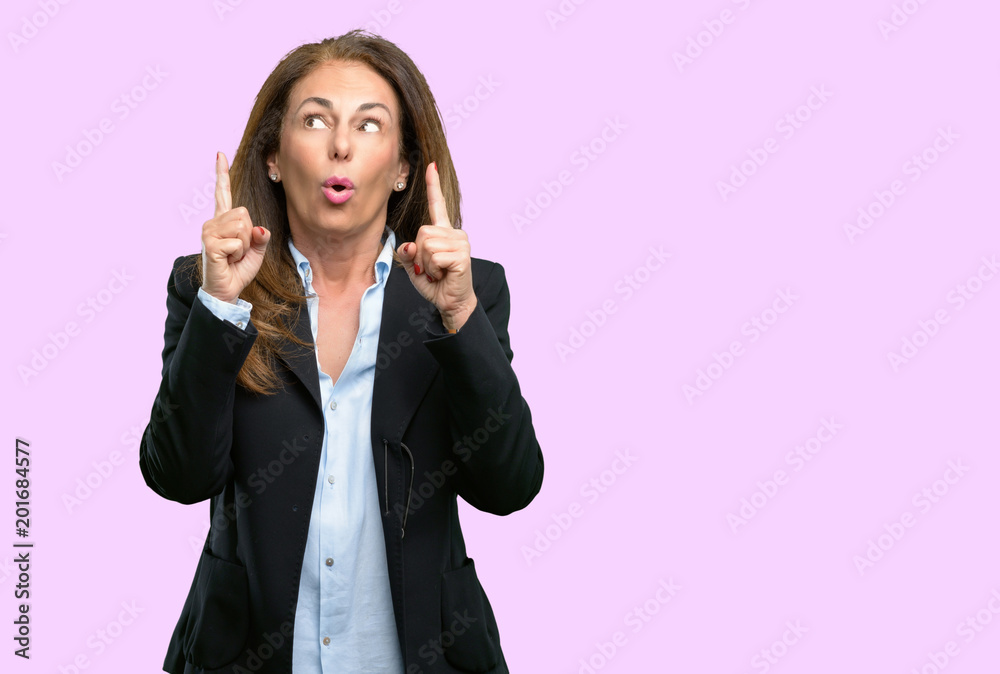 Middle age business woman happy and surprised cheering expressing wow gesture pointing up Middle age business woman happy and surprised cheering expressing wow gesture pointing up