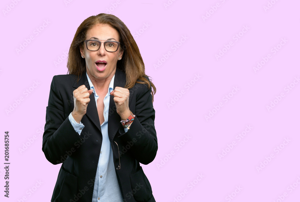 Middle age business woman happy and surprised cheering expressing wow gesture Middle age business woman happy and surprised cheering expressing wow gesture