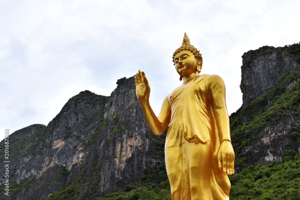The attitude of persuading the relatives not to quarrel symbol of Golden Buddha statue  with mountain background at Soun Wi Wek Buddhist Priests House,Sam Roi Yot, Prachuap Khiri Khan,Thailand
 - obrazy, fototapety, plakaty 
