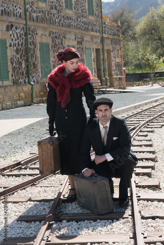 Young couple with vintage suitcase on the trainlines ready for a journey. photo