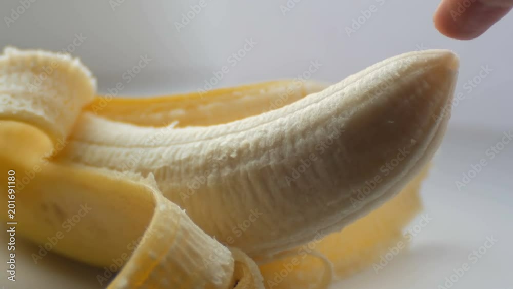 Woman sexually touching with a finger tip of purified banana, macro close up view Woman sexually touching with a finger tip of purified banana, macro close up view
