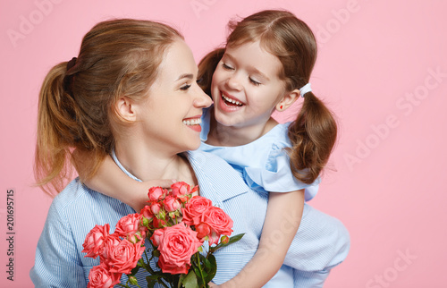 concept of mother's day. mom and child with flower on colored background