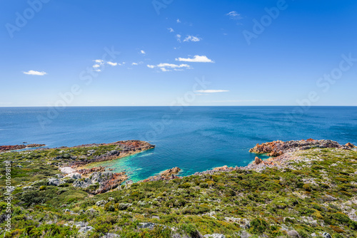 Stunning view from bright white light station to deep blue sea ocean bay turquoise water with orange red rocks at shore coast on warm sunny clear sky day, Rocky Cape National Park, Tasmania, Australia © Thomas Jastram