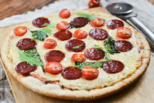 Tasty Pizza With Tomato Sauce, Pepperoni Sausage, And Mushrooms On Wooden Background Natural Rustic, A Pizza Cutter And Ingridienty. photo