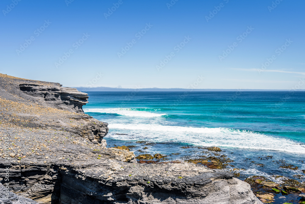Amazing view to stunning rocky sandy beach deep blue water of southern ocean antarctica on warm sunny day with blue sky after hiking on to South Cape Bay, South-West National Park, Tasmania, Australia