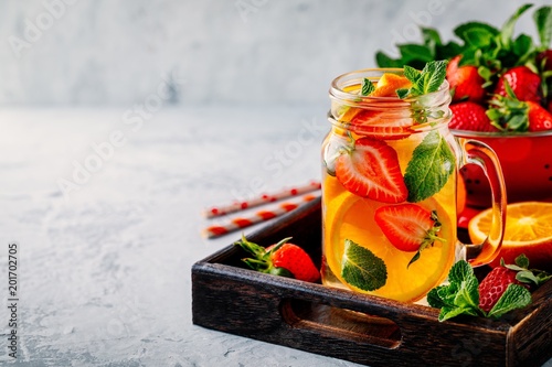 Infused detox water with orange, strawberry and mint. Ice cold summer cocktail or lemonade.