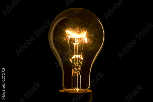 Abstract light bulb on the black background. Lamp light in the dark. Electric bulb. Glowing light in the dark. photo