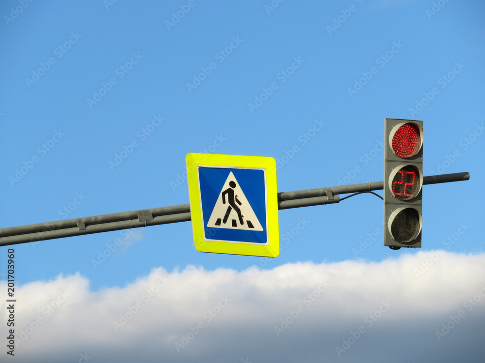 Pedestrian crossing sign and red traffic light on blue cloudy sky ...