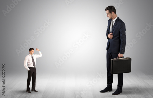 Big debutant young businessman scared of small strong businessman 