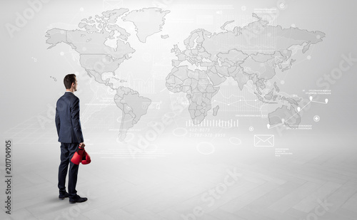 Businessman standing with his back and looking at a worldwide map with objects in his hand  