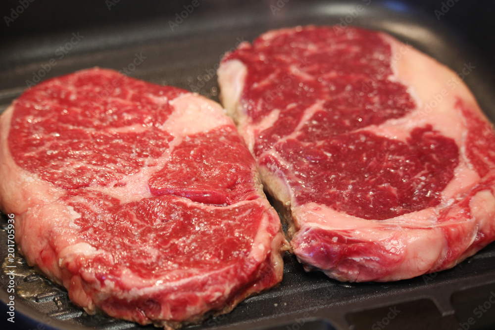 Raw steaks cooked on the pan