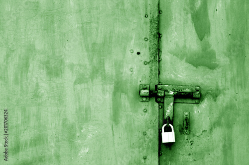 Old padlock on metal gate in green tone. © pavelalexeev