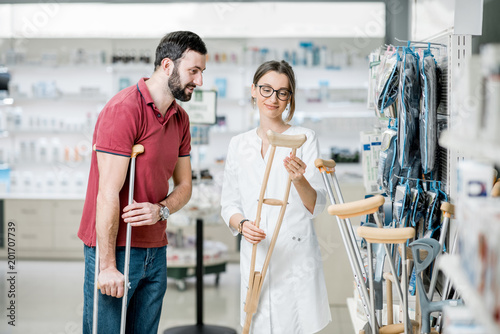 Canvas Print Man choosing crutches in the pharmacy