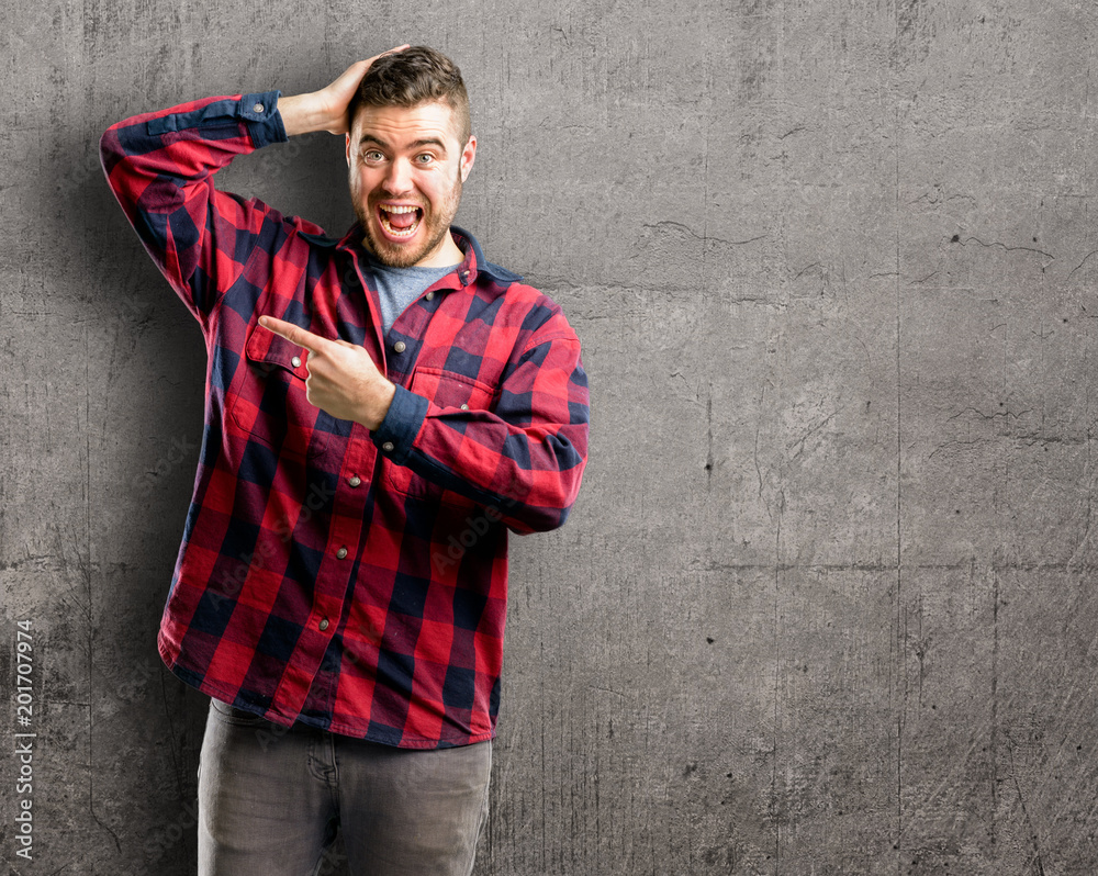 Young handsome man pointing away side with his finger