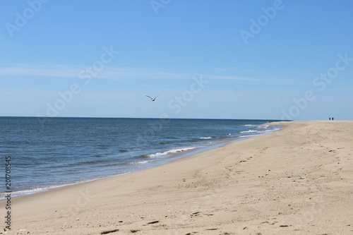 Waves crashing on isolated empty sandy coastal ocean beach 