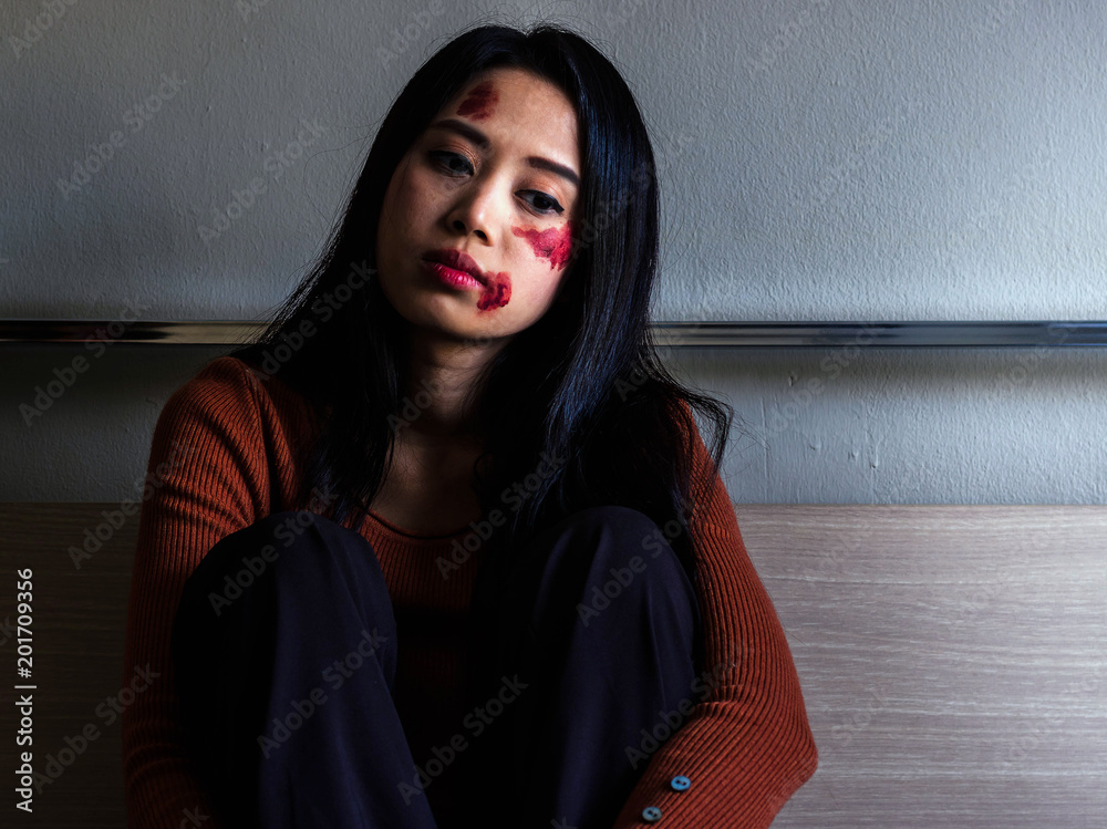 Obraz premium Sad girl sitting on the floor in corner of room.Unhappy depressed teenager