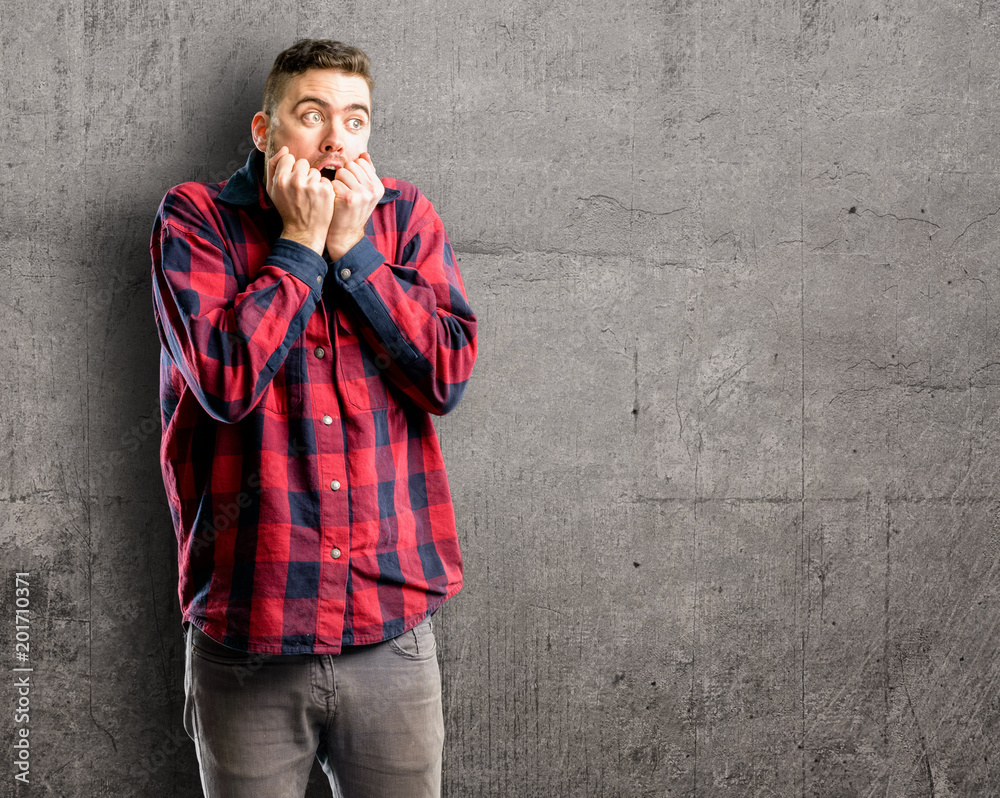 Young handsome man terrified and nervous expressing anxiety and panic gesture, overwhelmed Young handsome man terrified and nervous expressing anxiety and panic gesture, overwhelmed