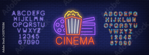 Cinema and alphabet neon sign set. Popcorn box, film reel, clapper board, violet colorful letters and numbers. Night bright advertisements. Vector illustrations in neon style for online movie