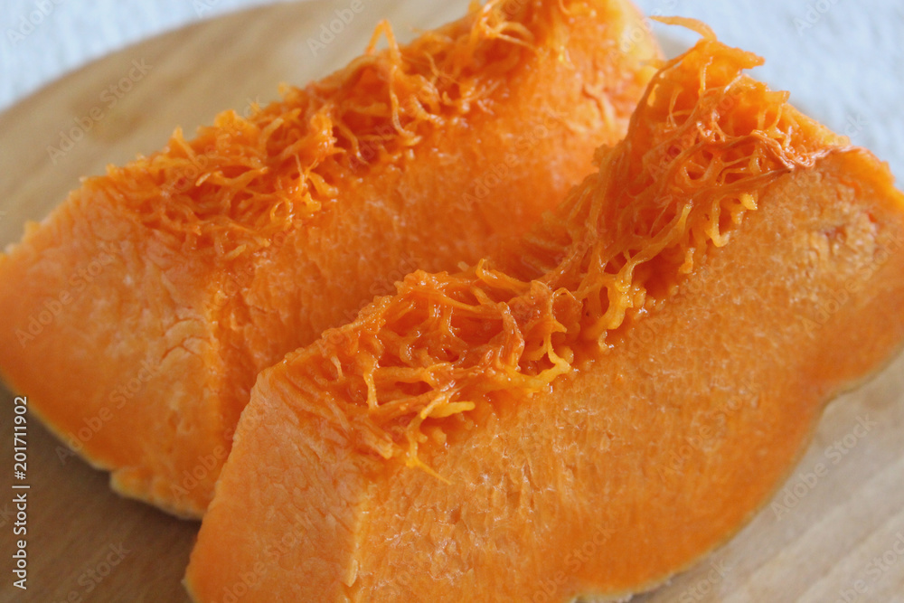 Pieces of raw pumpkin on the cutting board. Vegetarian healthy food Pieces of raw pumpkin on the cutting board. Vegetarian healthy food