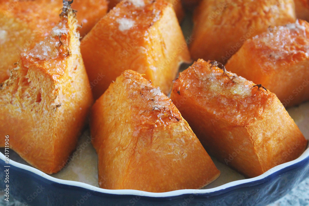 Baked pumpkin with sugar on a plate. Vegetarian healthy food Baked pumpkin with sugar on a plate. Vegetarian healthy food