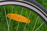 Ausschnitt eines Fahrrad Rades mit einem orangenen Reflektor