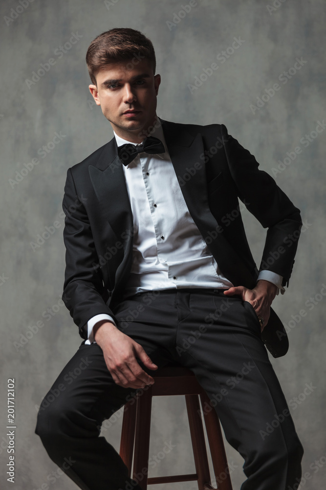 relaxed businessman dressed elegantly sitting with hand in pocket relaxed businessman dressed elegantly sitting with hand in pocket