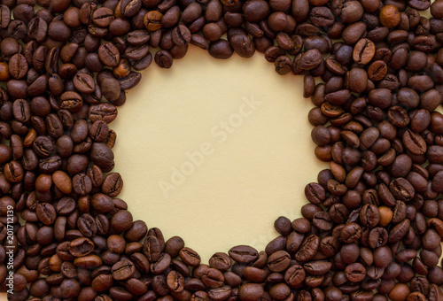 Roasted coffee beans with circle copy space in the middle. Aroma drink concept. Breakfast background. Coffee closeup with copy space. Cappuccino and espresso concept. 