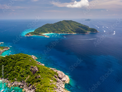 Aerial drone view of boats around the clear waters and tree covered Similan Islands in Thailand