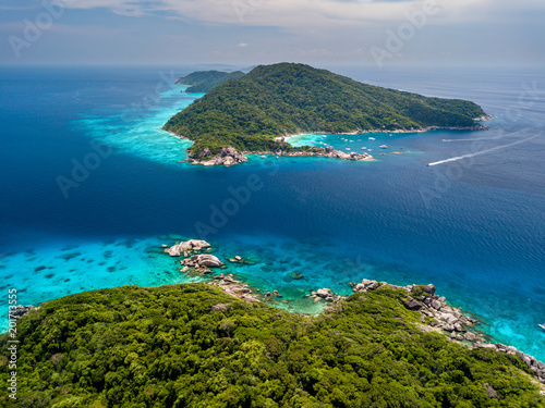 Fototapeta Naklejka Na Ścianę i Meble -  Aerial drone view of green tropical islands next to clear waters and a huge coral reef system