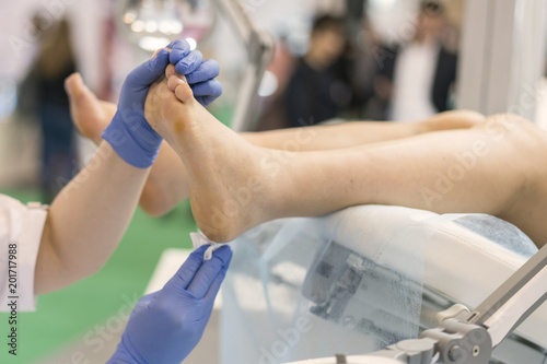 pretty doctor examining an elderly patient's foot