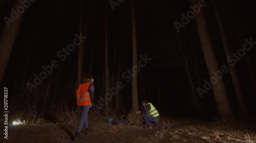 man and woman volunteers in a reflective waistcoat found a corpse in the forest